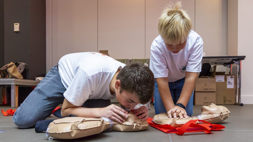 Zwei Kinder üben an Dummys Beatmung und Herzdruckmassage.