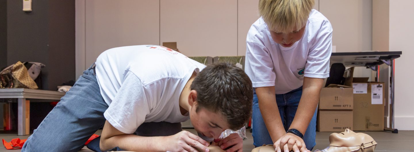 Zwei Kinder üben an Dummys Beatmung und Herzdruckmassage.