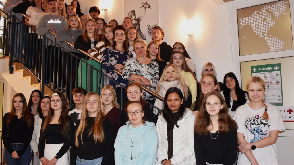 Rund 40 junge Menschen sind auf einer Innentreppe aufgereiht. Sie sind die neuen Auszubildenden der Pflegeschule des DRK im Kreisverband Lausitz.