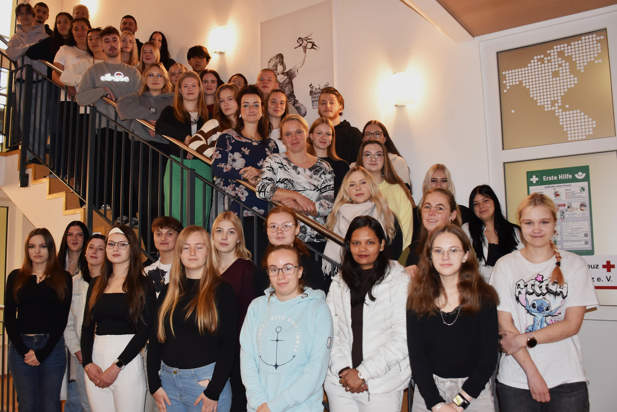 Rund 40 junge Menschen sind auf einer Innentreppe aufgereiht. Sie sind die neuen Auszubildenden der Pflegeschule des DRK im Kreisverband Lausitz.
