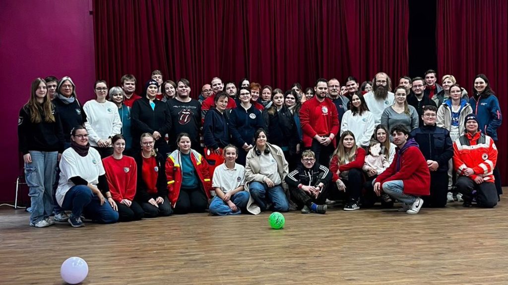 Gruppenleitungen des Jugendrotkreuz in Brandenburg stehen beim Landesforum für ein großes Gruppenfoto zusammen.