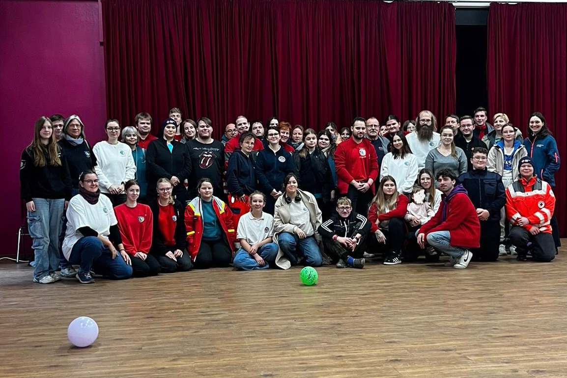 Gruppenleitungen des Jugendrotkreuz in Brandenburg stehen beim Landesforum für ein großes Gruppenfoto zusammen.