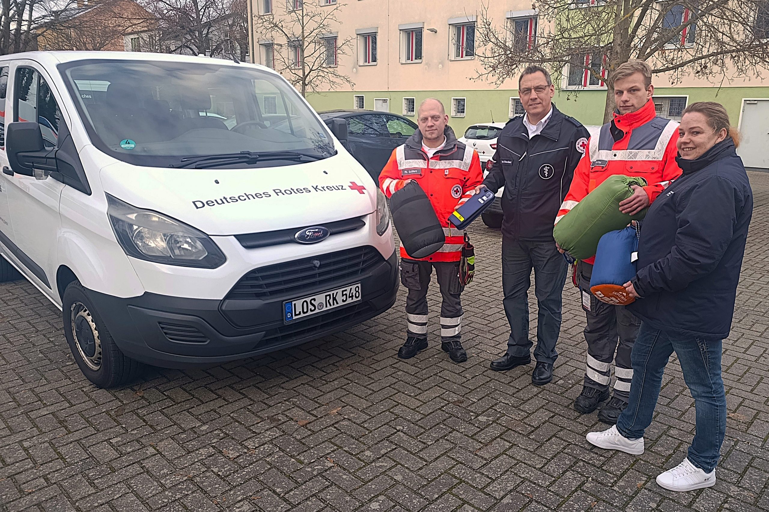 Bereitschaftsleiter Philipp Schillert, der stellvertretende Präsident Lars Wendland, Bereitschaftsmitglied Veit Zettier und Ehrenamtskoordinatorin Sabine Joeks (v. l.) neben dem Ford Custom, mit dem die Kältehilfe des DRK-Kreisverbandes Märkisch-Oder-Havel-Spree e.V. künftig in Frankfurt (Oder) unterwegs ist.